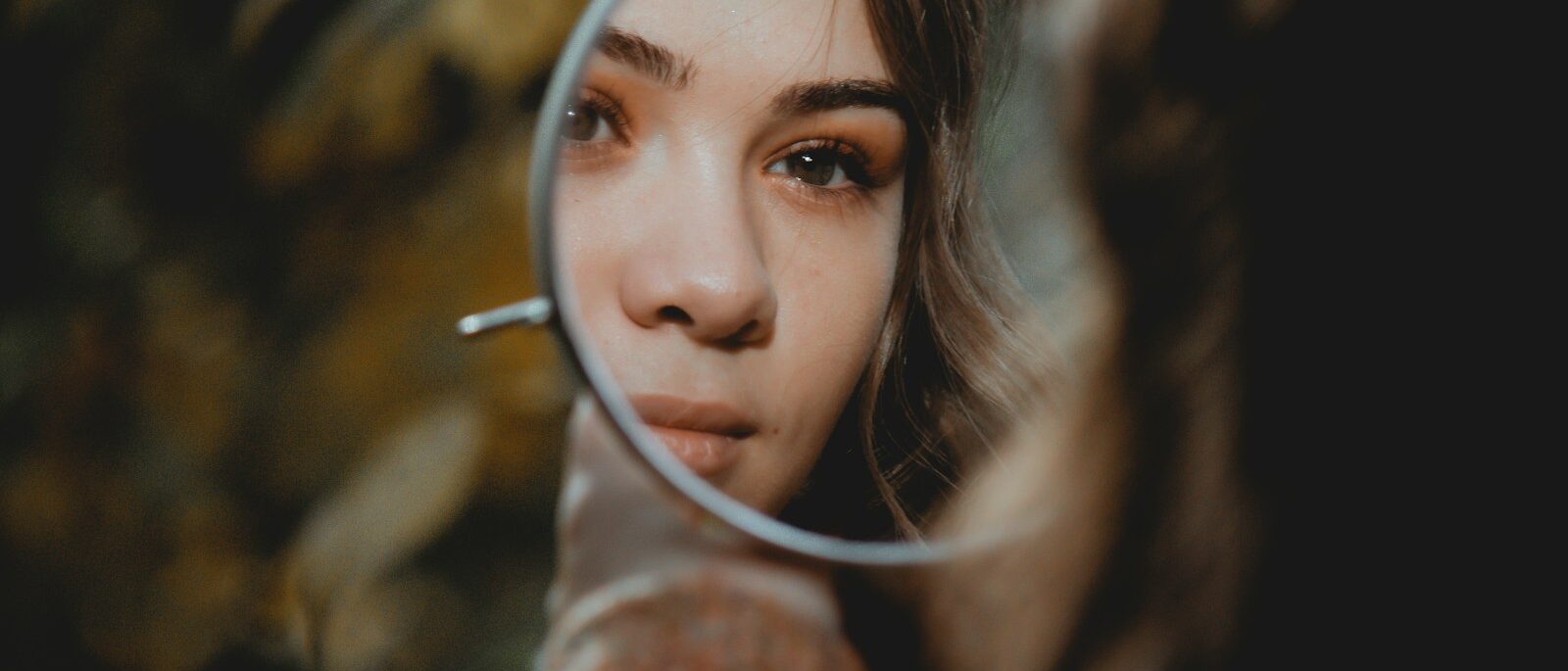 Woman holding magnifying glass, symbolising narcissistic abuse.